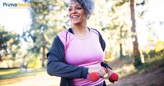 Woman walking outdoors with light dumbbells in her hands